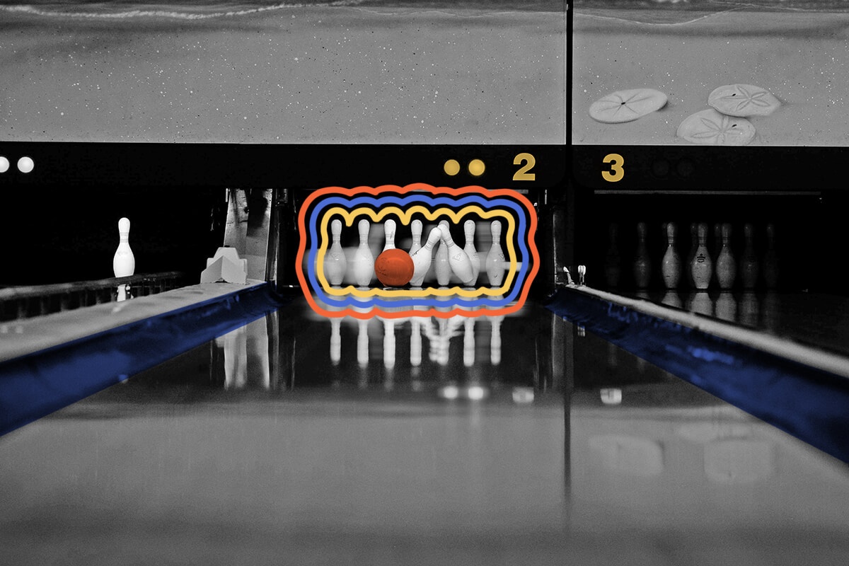 A bowling ball rolls toward a set of pins in an alley