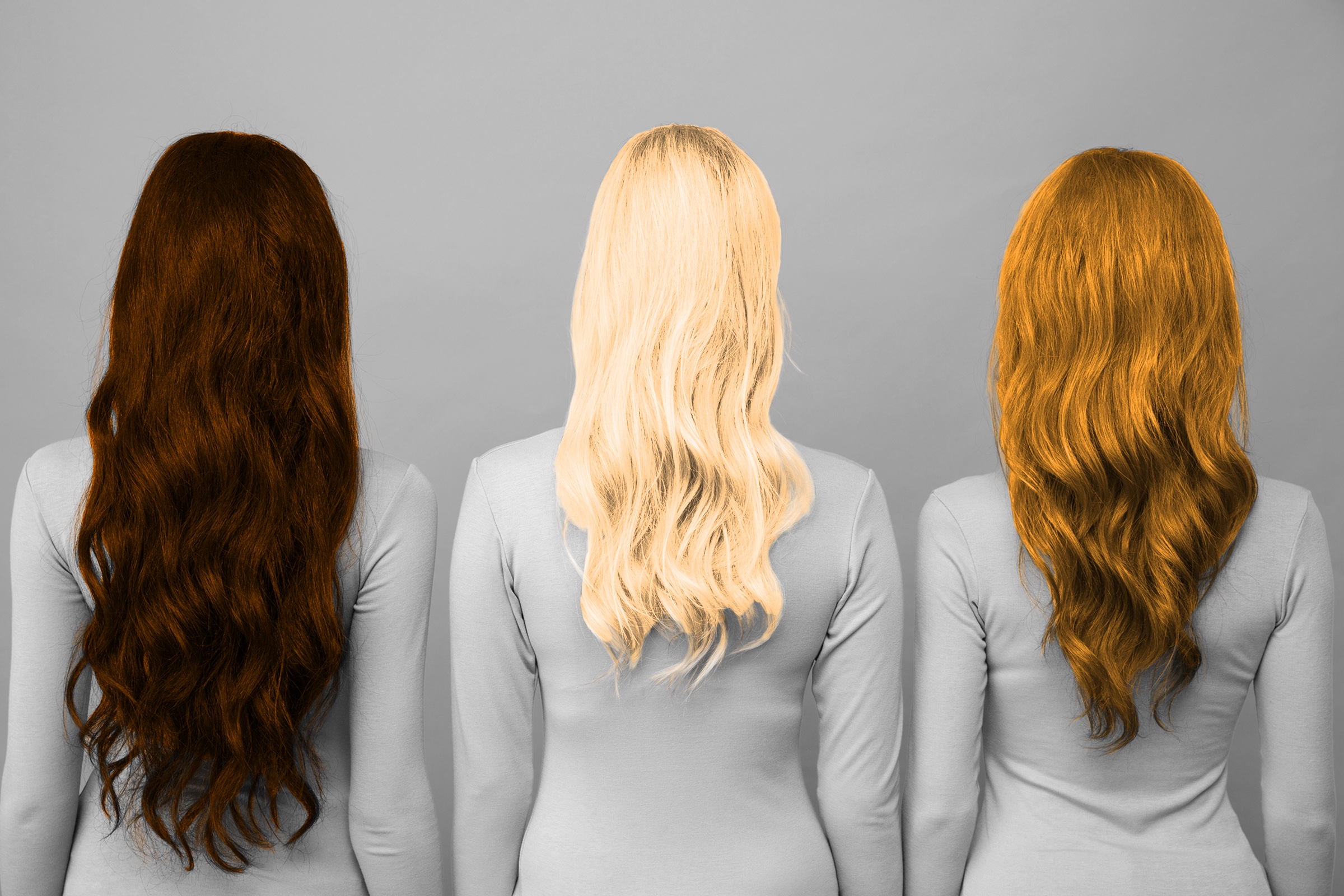 Three women with brunette, blonde, and red hair as seen from behind