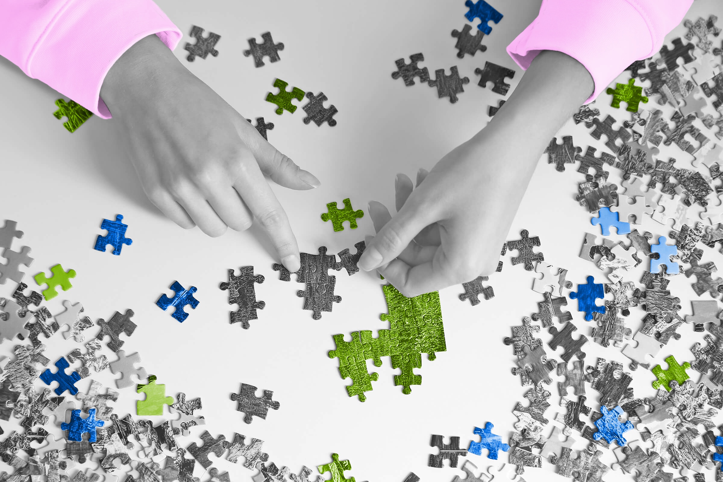 Hands putting together a jigsaw puzzle