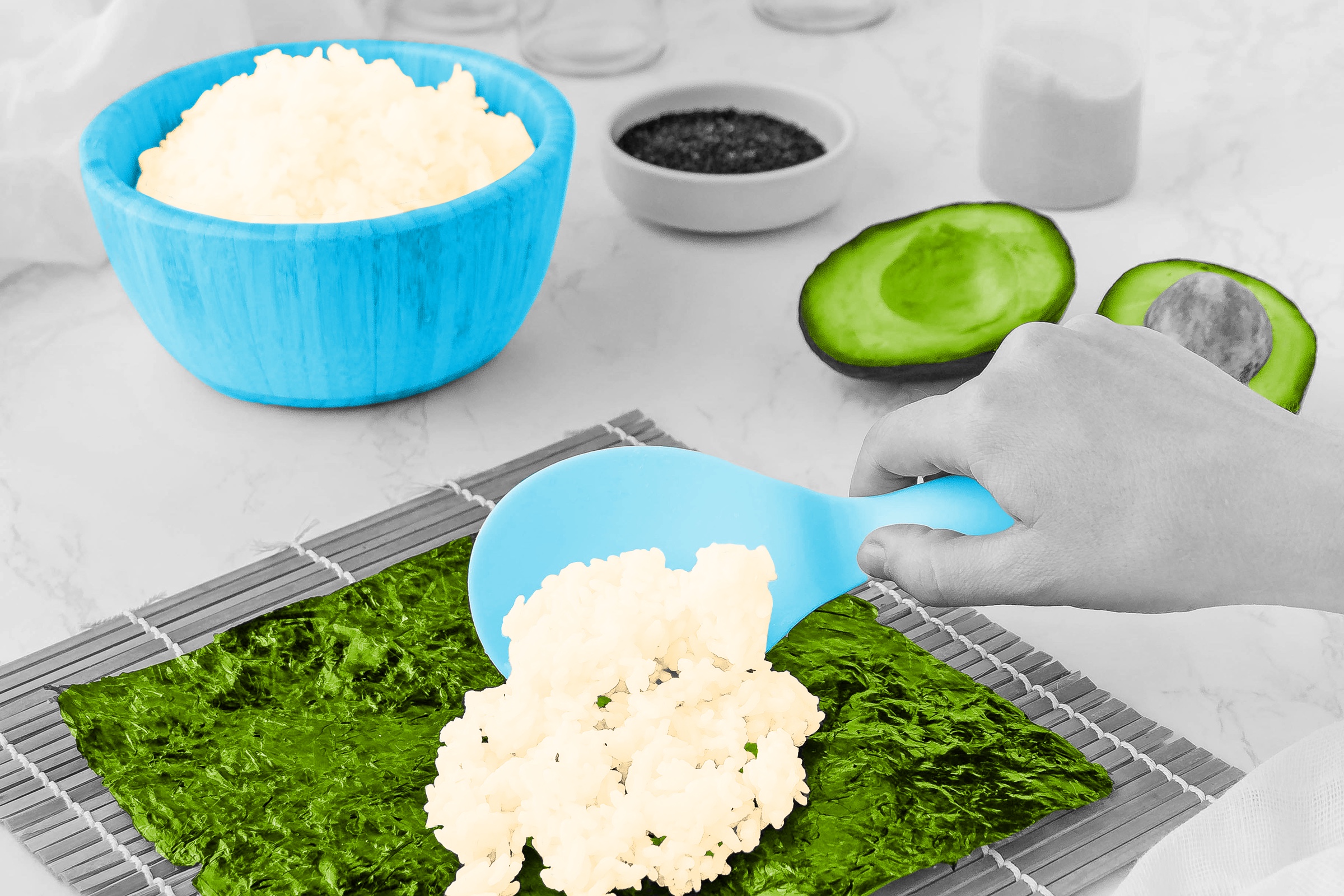 Person ladling rice onto a sheet of seaweed to make sushi