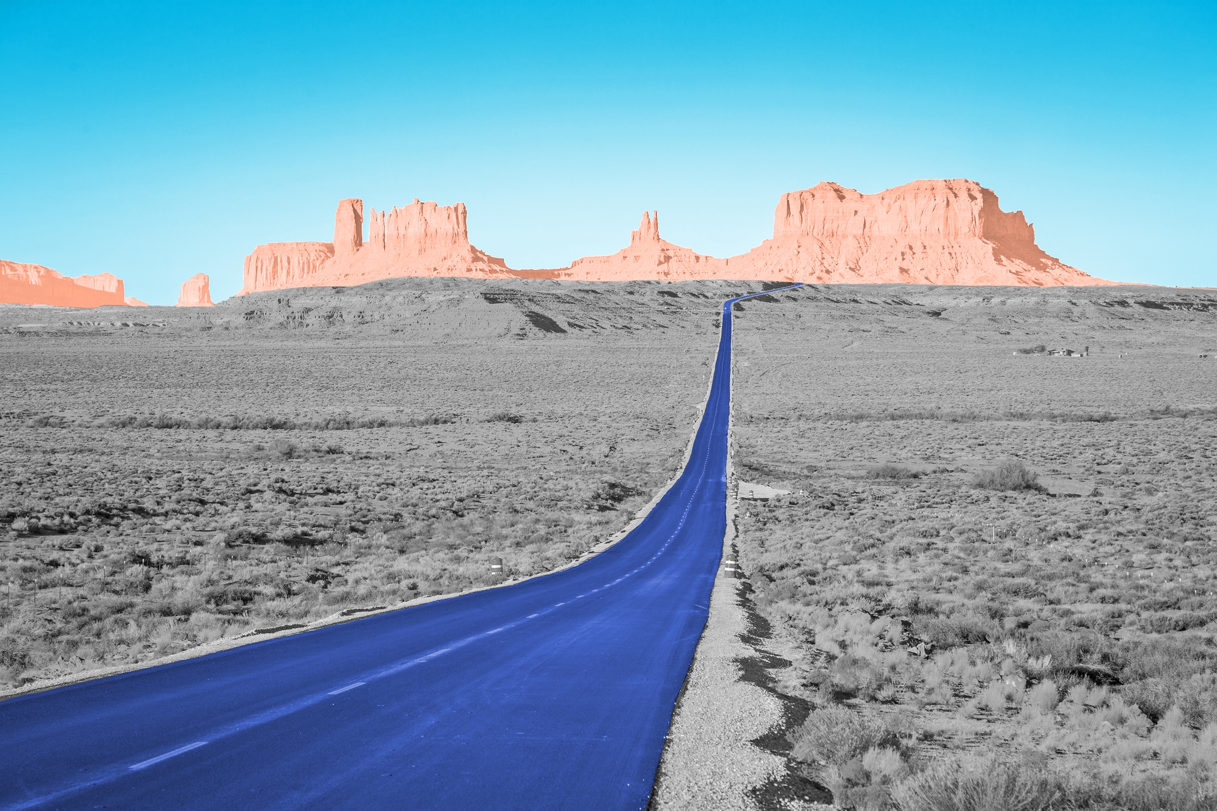 Long desert road leading to the Grand Canyon