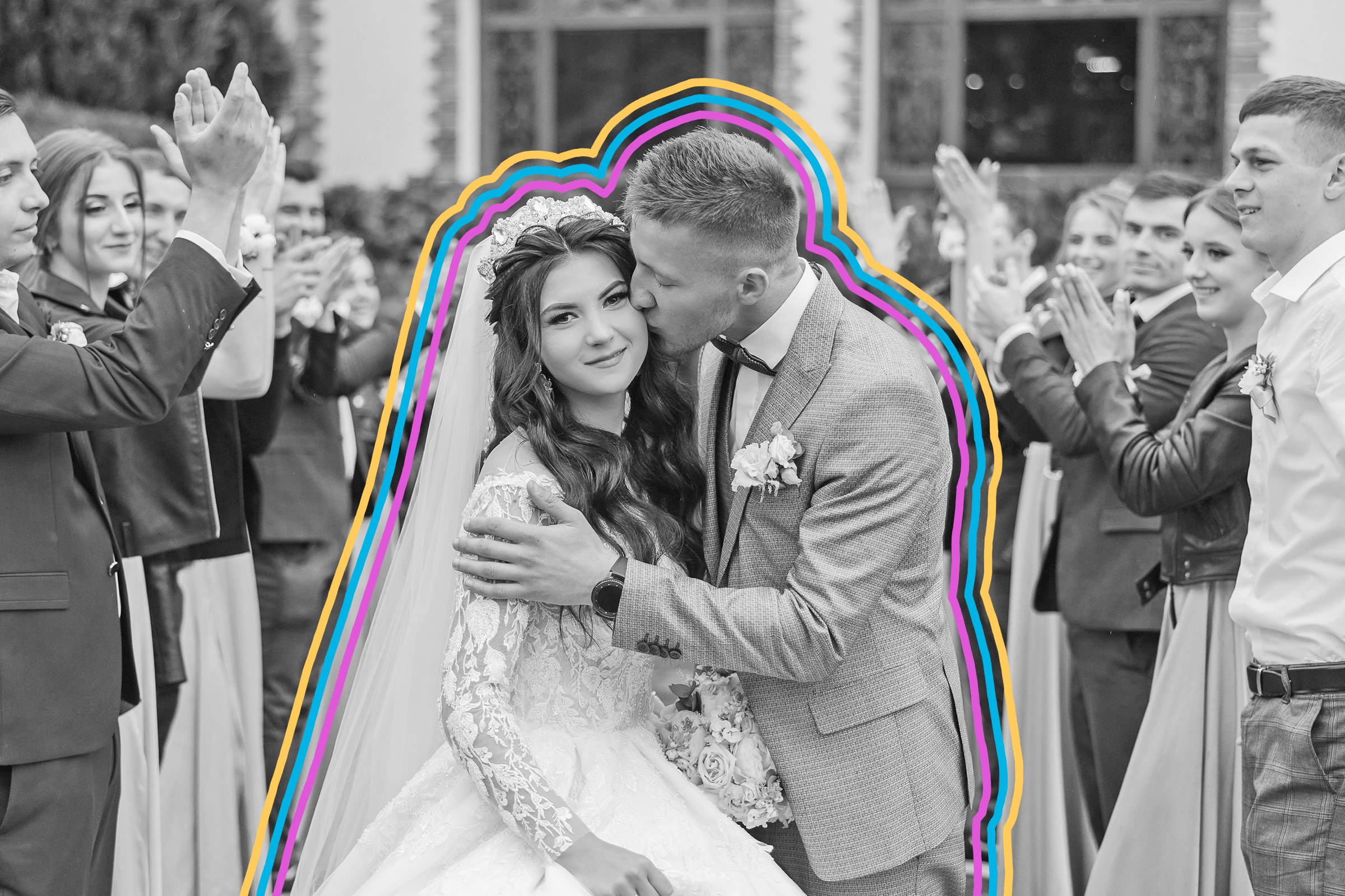Couple posing together on their wedding day surrounded by wedding guests