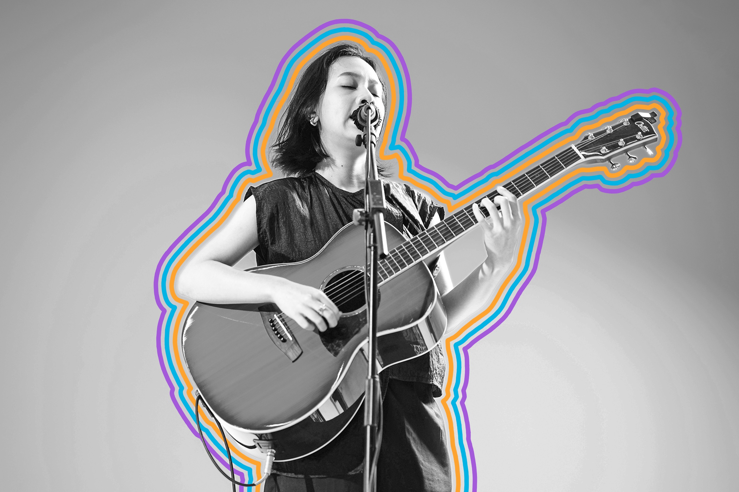 Person singing into a mic and playing guitar