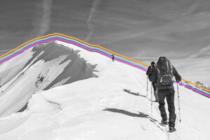 Hiker climbing the snowy peak of a mountain